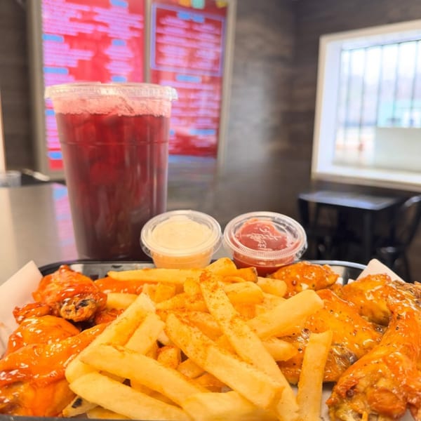 HP Taco Shop's buffalo wings and fries with dipping sauces and a red drink.